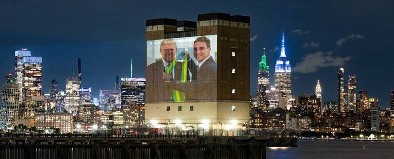 Protesto em Nova York usa Inteligência Artificial para criticar submissão de Flávio Bolsonaro e aliados a Donald Trump